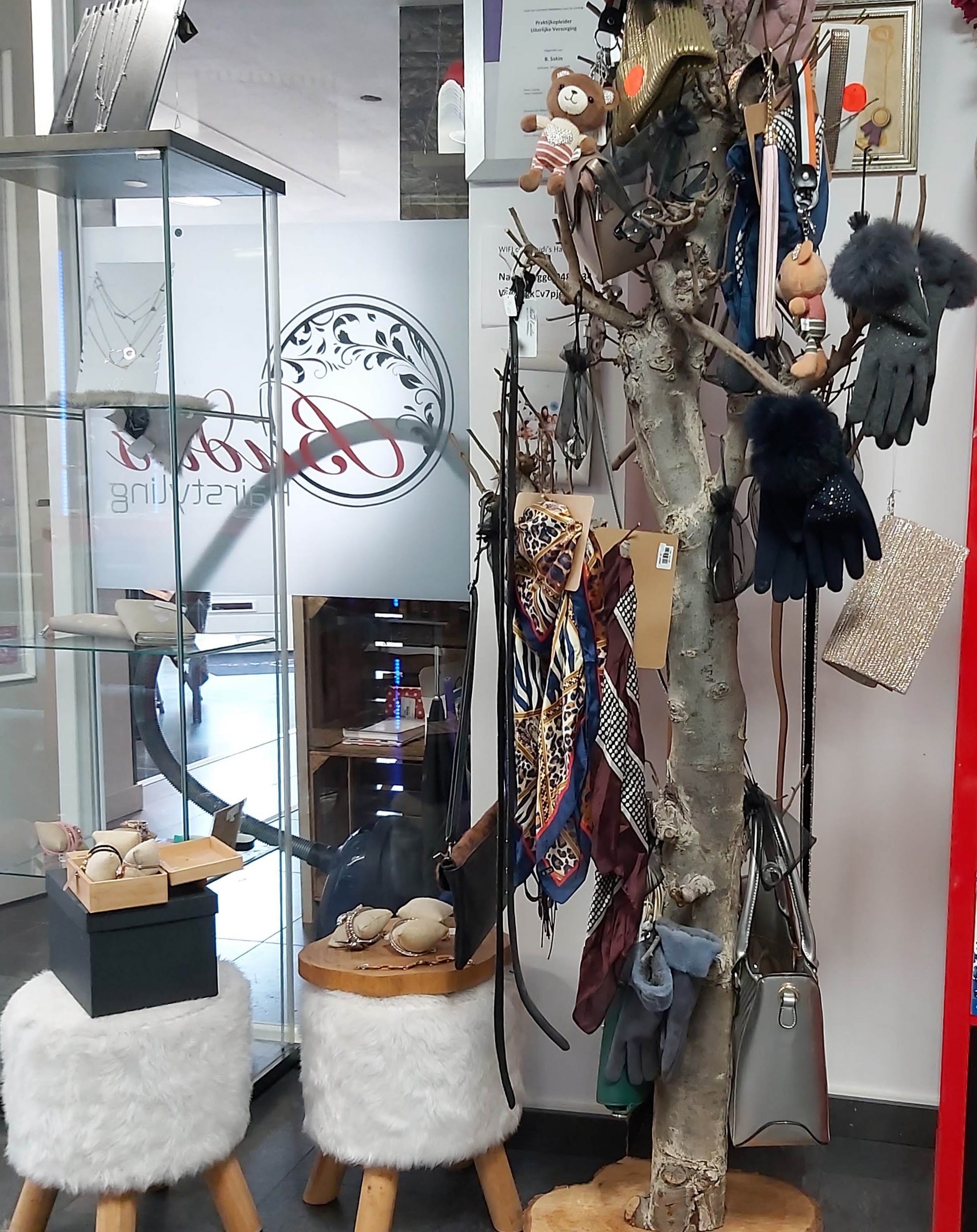 Accessoires en tassen bij het raam van Budi’s hairstyling